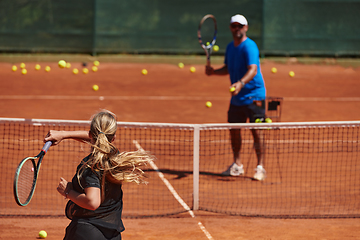 Image showing A professional tennis player and her coach training on a sunny day at the tennis court. Training and preparation of a professional tennis player