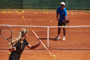 Image showing A professional tennis player and her coach training on a sunny day at the tennis court. Training and preparation of a professional tennis player