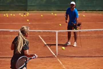 Image showing A professional tennis player and her coach training on a sunny day at the tennis court. Training and preparation of a professional tennis player