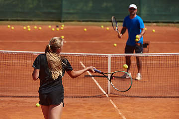 Image showing A professional tennis player and her coach training on a sunny day at the tennis court. Training and preparation of a professional tennis player