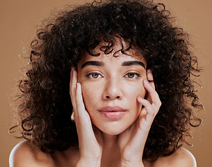 Image showing Woman, hands on face and afro hair care for beauty wellness in studio. Skincare dermatology wellness, African girl model portrait and cosmetics makeup headshot for healthy natural skin or facial care
