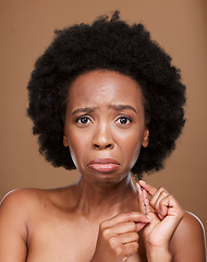 Image showing Portrait, hair and black woman in studio for problem, breakage and split ends against a brown background mockup. Afro, face and girl model unhappy with natural hair, tangle and curls with mock up