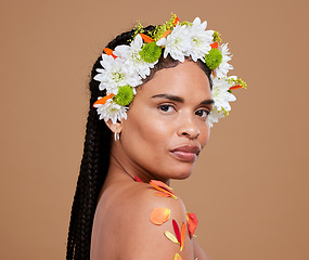 Image showing Portrait, beauty and flowers with a model black woman in studio on a brown background for skincare or natural wellness. Crown, makeup and plant with an attractive young female posing for luxury