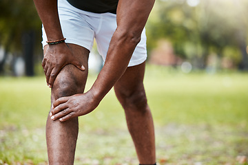 Image showing Sports, fitness and knee pain of black man at park after running outdoors. Healthcare, wellness and mature male runner with leg injury, muscle pain or joint inflammation after training or workout.