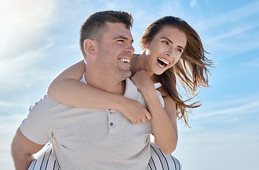 Image showing Love, beach and piggy back couple smile with blue sky on romantic summer holiday at ocean. Romance, man and woman have fun at sea for honeymoon, vacation time for happy couple together in Australia.