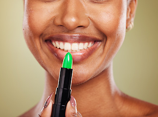 Image showing Green lipstick, mouth and lips with black woman and beauty closeup, lip care and cosmetic product against studio background. Face, makeup and wellness with glowing skin and natural cosmetics smile.