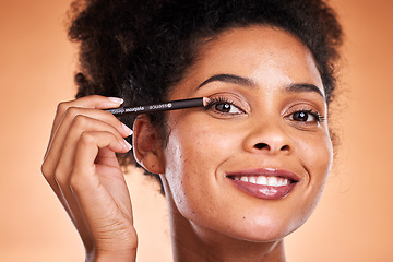 Image showing Beauty, skincare and makeup with black woman using eyeliner on eye for facial cosmetics product on a orange studio background. Face portrait of aesthetic model with smile and happiness for self care