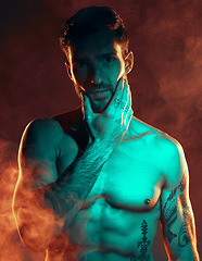 Image showing Fitness, tattoo and man in studio for wellness, exercise and body goals with smoke, fire and danger aesthetic. Portrait, sexy and male model with misty atmosphere pose for training, muscle and power