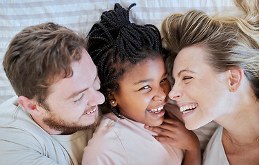 Image showing Family, love and bed fun of a mom, dad and adopted girl laughing with a funny time at home. Portrait of a interracial child with mama and father smile bonding with parent care in a house bedroom