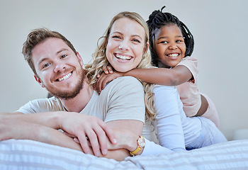 Image showing Family, parents and child in interracial portrait on bed with smile, love or happy bonding together in home. Bedroom, multicultural diversity and black girl with foster mom, dad or happy family relax