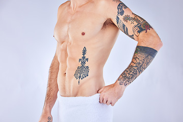 Image showing Tattoo, man or stomach in towel in for health, wellness and muscle in studio background with mockup space. Zoom of muscular, skincare and model body ink for six pack, beauty and studio or mock up