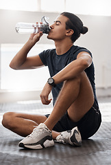 Image showing Water bottle, fitness and gym man tired after a fitness training, exercise challenge and wellness goal with healthy diet or nutrition. Young sports person floor drinking water for healthy lifestyle