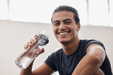 Image showing Fitness, water bottle and portrait of a man on a break after an intense workout or training in the gym. Sports, rest and happy athlete drinking a beverage while resting after exercise in sport center