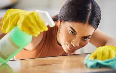 Image showing Black woman, hands and detergent for cleaning hygiene, domestic or health and safety from bacteria at home. African American female spraying wooden table, counter top or furniture for clean sanitary