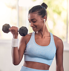 Image showing Woman, dumbbell and music earphones in gym workout, training and exercise for strong arm muscles, body goals or strength target. Indian athlete, personal trainer or fitness coach weightlifting metal