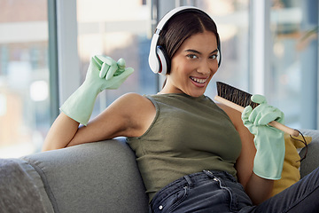 Image showing Spring cleaning, singing and woman, portrait and music, headphones and fun in living room, lounge and sofa. Happy cleaner, karaoke and audio listening while dusting furniture in house, home and couch