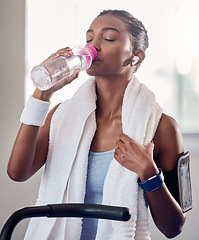 Image showing Fitness, health and woman drinking water in gym, rest and drinking while listening to music streaming app. Training, exercise and water, girl stop on treadmill or exercise bike, relax during workout.