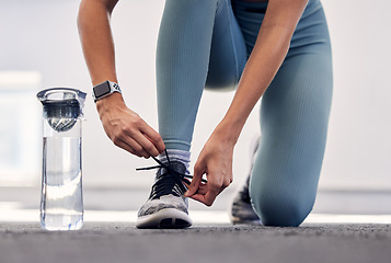 Image showing Fitness, woman and shoe for running preparation, workout or training exercise with water bottle in the outdoors. Female tying laces getting ready for sports exercising, run or healthy cardio outside