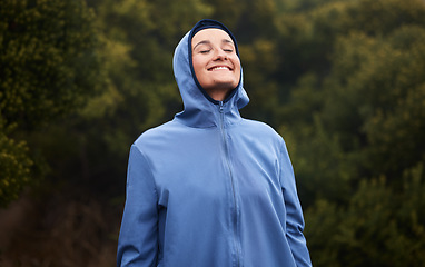 Image showing Nature, happiness and woman with raincoat, smile and wellness standing in outdoor park. Peace, calm and girl enjoying natural environment, spring and fresh air hiking, walking and exercise in forest