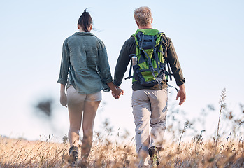 Image showing Couple, holding hands and travel or backpack adventure in bonding relationship together in the countryside. Hands of man and woman backpacking, trekking or walking in care or support for traveling