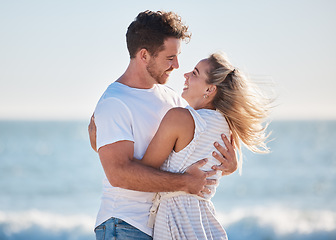 Image showing Love, beach hug and couple smile together at the ocean for peace, relax in nature and romance vacation happiness. Happy man, laughing woman and relationship bliss on a travel holiday by sea