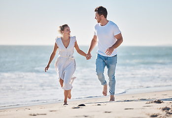 Image showing Couple, beach and love for walk, romance and love in relationship bonding, care and quality time. Man, woman and happy by sea, ocean and sand together with happiness, holding hands and outdoor in sun