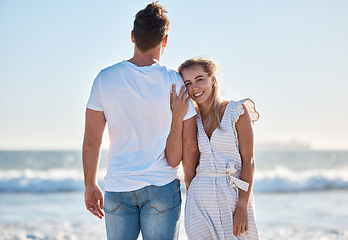 Image showing Couple, love and beach sunset at the ocean while travel, bond and relax in nature together, happy and smile. Portrait, woman and rear view of man embrace, care and enjoy trip to Florida on blue sky