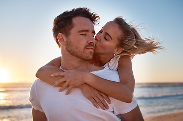 Image showing Love, couple and cheek kiss at beach on date, vacation or summer trip. Sunset, affection or romance of man and woman kissing at seashore, bonding and enjoying quality time together outdoors at coast.