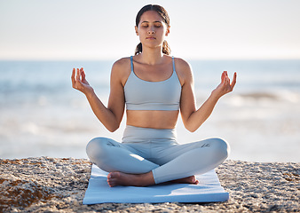 Image showing Calm, beach and woman doing meditation exercise for zen, health and wellness of the mind and body. Spiritual, fitness and healthy girl in lotus pose doing yoga or pilates workout by the ocean or sea.