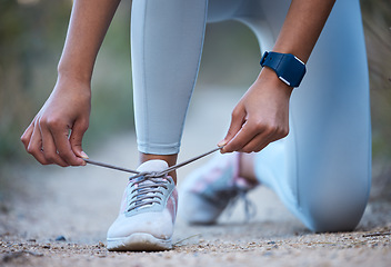 Image showing Fitness, exercise and woman tie shoe after running, workout and marathon training in nature. Sports, wellness and closeup of hands tying lace on sneakers for performance, run and exercising outdoors