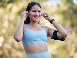 Image showing Woman, fitness and music with an athlete wearing earphones for motivation songs before a exercise workout in nature. Working out, running and athletic female streaming a podcast on her phone outside