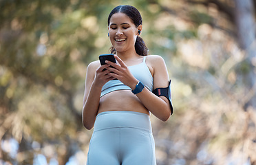 Image showing Phone, earphones and woman in nature for fitness, running music or radio, podcast or audio outdoors. Wellness, health or female athlete on 5g mobile smartphone browsing social media on training break