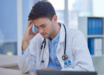 Image showing Stress, headache and doctor with burnout sitting at his desk feeling depressed with in pain in hospital. Mental health, medicine and healthcare with frustrated male gp or physician feeling overworked