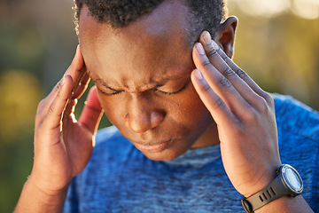 Image showing Headache, pain and stress of a man hiking in nature on a trail for health, wellness and fitness. Adventure, medical emergency and African guy holding his injured head while trekking in the woods.