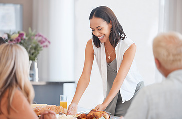 Image showing Happy woman hosting food at dinner table in home, house and dining room for family lunch, meal and social gathering together. Party, celebration and eating in family home, lifestyle and happiness