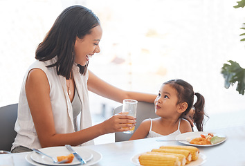 Image showing Woman, food and eating at home for health, wellness and diet nutrition at the dining table. Meal, lunch and mother and daughter eat and drink juice together for hungry child in the family home