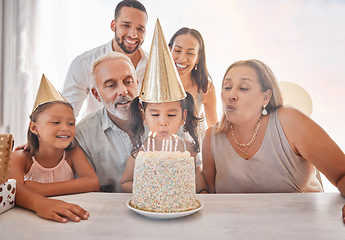 Image showing Birthday, family and girl blowing candles on cake with party hats, parents and grandparents in home. Happiness, big family and happy young child make a wish on festive celebration and birthday party