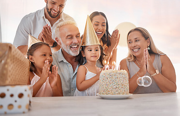 Image showing Family, birthday party and cake with celebration, clapping and singing with candle or gift on table in home. Girl, parents and grandparents with sister celebrate event in house with birthday cake