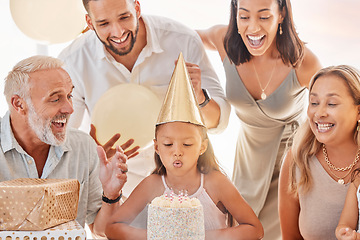 Image showing Birthday cake, blow candle and family celebration, party and singing with decorations, event and gift in home. Happy birthday, birthday party or candles for girl with parents, grandparents or balloon