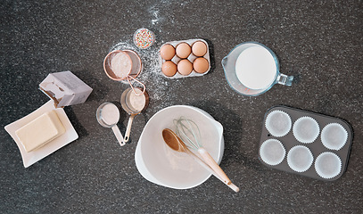 Image showing Top view, baking product and kitchen counter with eggs, flour and butter utensils on table. Food and cooking ingredients on a table to bake meal or dessert with protein and nutrients from above