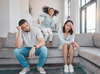 Image showing Tired, couple and family with adhd girl jump fast on sofa in house living room or home. Man, woman and parents with burnout, depression or anxiety from autism, energy and mental health kid and stress