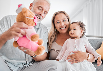 Image showing Mature, couple and baby with a toy while babysitting grand daughter with love, care and affection for fun playing. Caring, living room and grandfather, grandmother and child bonding with teddybear