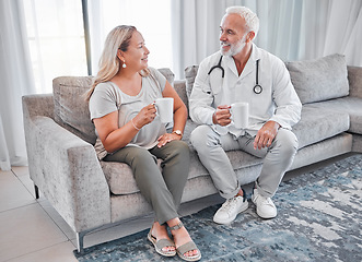 Image showing Home visit, doctor and woman on sofa talking and drinking coffee in living room after consulting. Healthcare, medicine and a medical professional man and lady on couch in house or apartment with tea.
