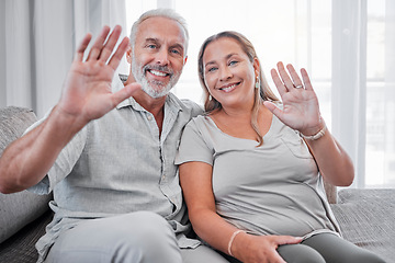 Image showing Elderly couple, relax and smile in hello for introduction, waving hands or video call on living room sofa at home. Portrait of happy senior man and woman smiling in happiness for communication