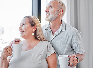 Image showing Elderly couple, hug and coffee by window with smile in contemplation, vision or morning routine at home. Happy senior man and woman smiling looking out glass while enjoying a warm drink together