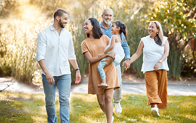 Image showing Big family, walking in a nature park and happy smile with black people walking on grass in summer sunshine for bonding, love and quality time together. Grandparents, father with mother and daughter