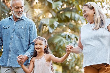 Image showing Park, holding hands and grandparents with child for outdoor walking, nature wellness and development in summer, holiday and travel. Happy girl with senior family in garden bonding together with love