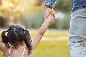 Image showing Holding hands, care and girl with father in a park with safety, support and security. Walk, trust and back of a child with dad in a backyard, field or nature in countryside for outdoor quality time