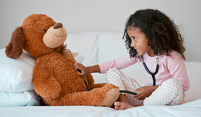 Image showing Teddy bear, learning and child with stethoscope for healthcare, heart and anatomy education in her bedroom and home for development. Girl play with hospital, doctor or nurse cardiology toys or tools