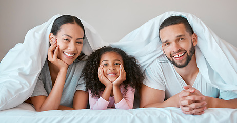 Image showing Relax, happy and girl with her parents in bed for security, love and safety under blanket in their family home. Support, smile and portrait of a child with her mother and father in the bedroom